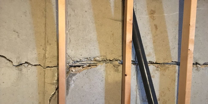 Cracked basement wall with exposed rebar